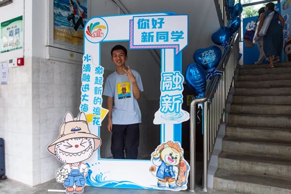 新生在欢迎立牌下开心留影（张颢瀛 摄）.jpg
